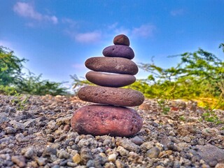 depicts rock balancing, also known as stone stacking or rock stacking. 