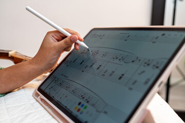 Musician composing music on digital tablet with stylus