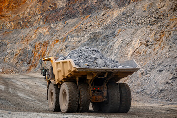 Transporting Open pit mine industry, big yellow mining truck for gold, copper, iron ore
