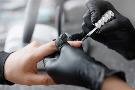 Closeup process manicure for young caucasian female with black gloves - Powered by Adobe
