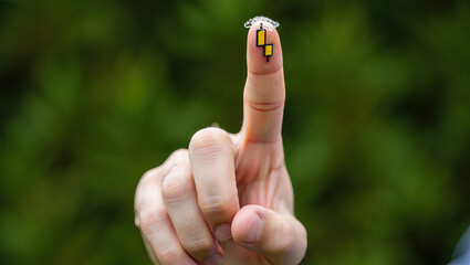 Fototapeta premium Close Up of a Finger Touching a Small Electronic Device Attached to the Skin Demonstrating Advanced Technology and Wearable Sensors for Health Monitoring and Data Collection