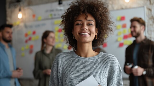 happy young african american woman brainstorming marketing ideas about project strategy among diverse multiracial coworkers business startup creative team or students group in office holding papers n