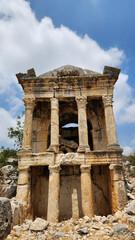 Fototapeta premium Built in the 2nd century AD in Demircili, north of Silifke, Mersin, within the ancient Imbriogion settlement, this two-story monumental tomb features architectural decorations, an inscription, reliefs