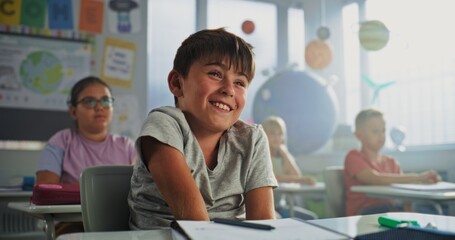 Primary School Boy Sitting at Desk, Raising Hand and Giving Correct Answer on Teacher's Question During Geography Lesson. Group of Young Boys and Girls Learning Science in Modern Colorful Classroom.