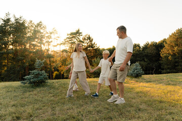 A family enjoying a walk in nature with warm lighting and a joyful atmosphere