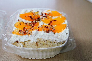 Peach cake with whipped cream and nuts sitting on table