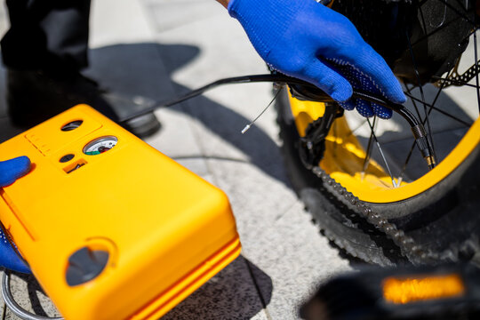 Using a portable air pump to inflate a bicycle tire on a sunny day