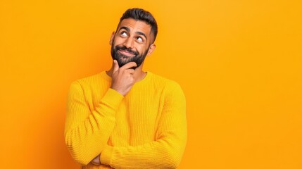 Obraz premium happy joyful smiling young indian man looking aside up thinking of new good opportunities dreaming feeling inspired and proud standing isolated on yellow background portrait no logos no brands ar 169
