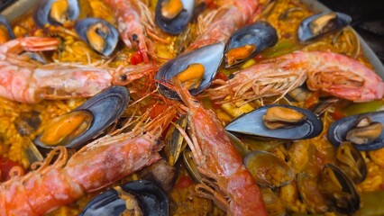 Traditional spanish paella with seafood shrimp and mussels. Close-up. Typical cuisine of Spain. Valencian cuisine. Stage of cooking paella. Ingredients for paella