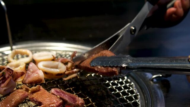 Man hands Flip tentacles while Cooking octopus on a barbecue grill. seafood texture. High quality 4k footage
