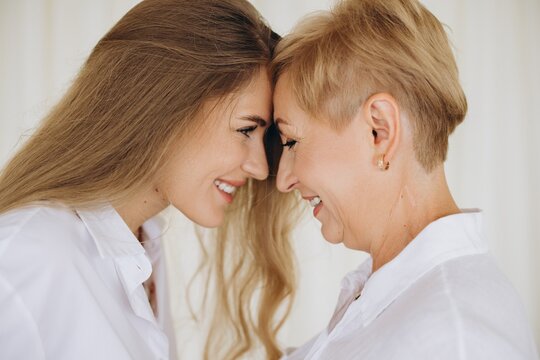 Mother and daughter touching foreheads and smiling