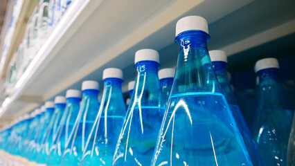 Close-up of blue water bottles standing in a row