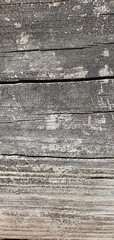 Close-up of weathered wooden planks with aged texture, cracks, and faded paint, ideal for use as a rustic or vintage background