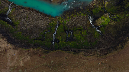 Aerial View of Turquoise River and Waterfalls in Iceland's Mossy Terrain
