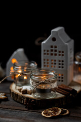 Creating holiday mood, festive atmosphere at home. Christmas spirit, atmospheric composition with handmade aroma candles made from simple glass jars, homemade gingerbread cookies, anise cinnamon scent