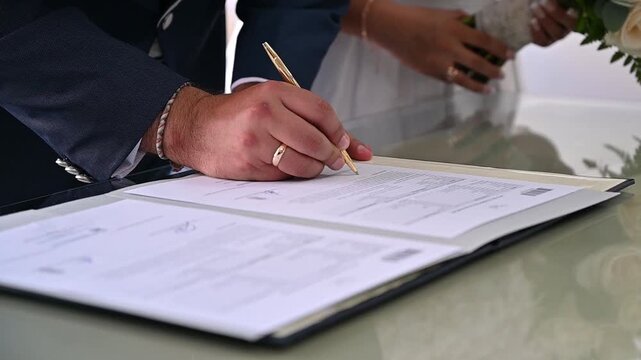 Groom signing marriage certificate during wedding ceremony