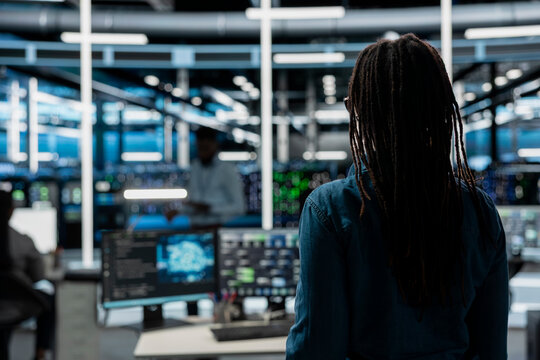 System administrator entering data center office, preparing to use artificial intelligence computerized model. Server room employee arriving at work, starting job shift, using AI