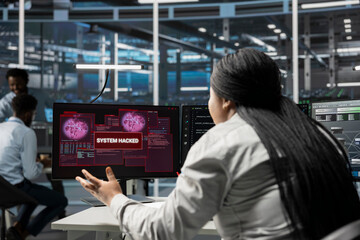 IT expert using PC in server farm to protect hardware from hacker attack stealing sensitive information. Data center employee seeing security breach alert on monitor, struggling to protect equipment