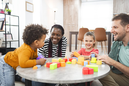 Multiracial family playing with colorful blocks indoors