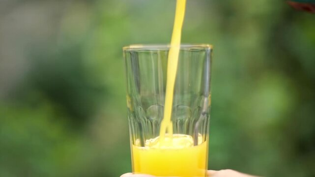 orange juice being poured into a glass