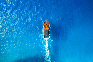 Aerial view on fast boat on blue sea at sunny day. Seascape with motorboat. Vacation and leisure....