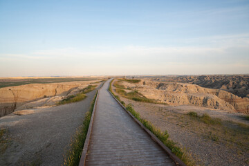 Wooden boardwalk trail at sunrise in Badlands National Park, South Dakota