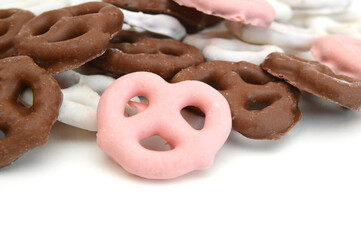 Colorful chocolate covered pretzels on white background