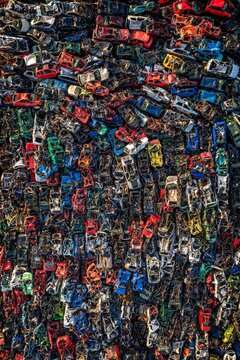 Aerial view of a colorful graveyard of crushed cars, a testament to time and technology, scattered across the landscape, Poland.