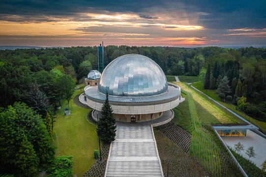 Aerial view of the Planetarium Grudzi&Auml;&hellip;dz dome glistening under the soft glow of the setting sun, nestled amidst verdant trees, Grudzi&Auml;&hellip;dz, Poland.