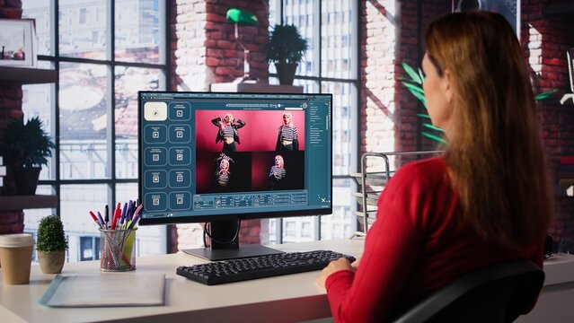 Woman expert developer works with photo editing software in her loft, digital media. Using dual monitors to ensure productivity and innovation in the graphic design world. Camera B.