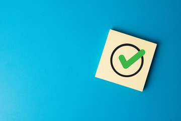 A check mark symbol on a note. A concept for quality control (QC), assurance (QA), verification,...