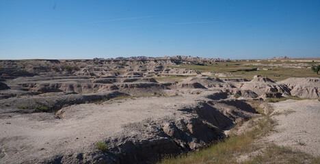 Open grassland with distant Badlands rock formations.