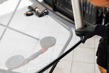 Applying adhesive to a car windshield using a caulking gun. Urethane caulking gun applies flexible...