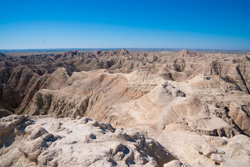 Layered rock formations under clear sky in Badlands National Park, South Dakota