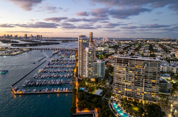 Obraz premium Aerial view of luxury yachts in Miami marina. Scenic panorama of boats and skyscrapers in Miami marina. Cruise yacht sailing along the Miami coastline. Miami Beach harbor. Sailboats and yachts at pier