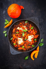 Greek style minced beef meat ragout stew with pumpkin, feta sheep cheese and capers in tomato sauce served as top view in cast iron pan