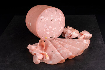 Traditional Italian artisan handcrafted fine mortadella with pistachio and truffle offered as close-up on design black board with copy space © HLPhoto