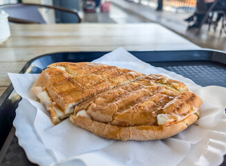 View of a Portuguese toasted bread with melted cheese placed on a plate