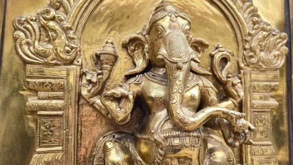 Singapore - 5 July 2025. A brass panel at Sri Mariamman Temple depicts Lord Ganesha in seated posture with fine detailing on his trunk, hands, and surrounding frame.