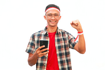 An Asian man wearing a red and white ribbon and holding a mobile phone. Celebrating Indonesian...