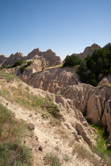 Eroded rock formations and green trees in Badlands National Park, South Dakota