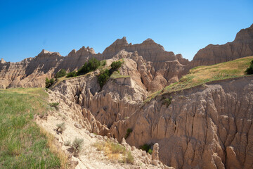 Eroded rock formations and green trees in Badlands National Park, South Dakota