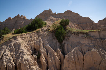 Eroded rock formations and green trees in Badlands National Park, South Dakota