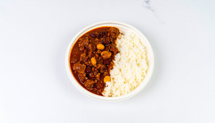 Overhead view of a bowl with chickpea curry and white rice on a marble surface
