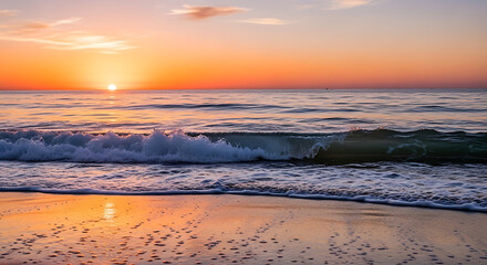 Obraz premium Vibrant orange sunset over a calm ocean with gentle waves on a sandy beach