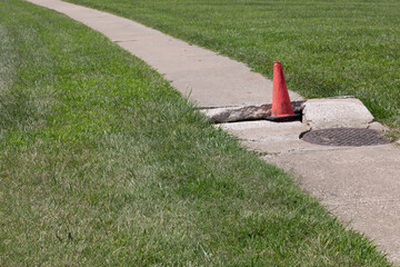 Damaged Sidewalk with safety cone