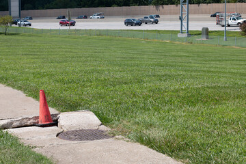 Damaged sidewalk with traffic in distance