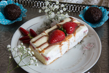 Strawberry cake on white plate with chocolate and red pepper.