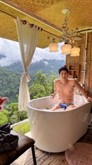 Handsome Man Relaxing in Bubble Bath on Veranda Amidst Lush Green Forest and Gentle Rain