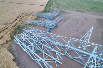 High-voltage pylon disassembled on ground with concrete bases before helicopter installation